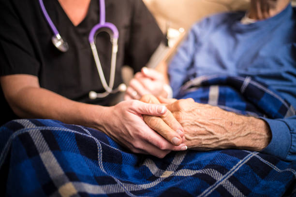 A stock photo of a Hospice Nurse visiting an Elderly male patient who is receiving hospice/palliative care.